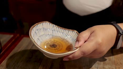 person pouring water into a decorative bowl