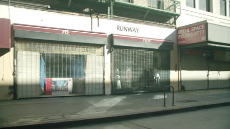 closed storefronts with security gates on an urban street