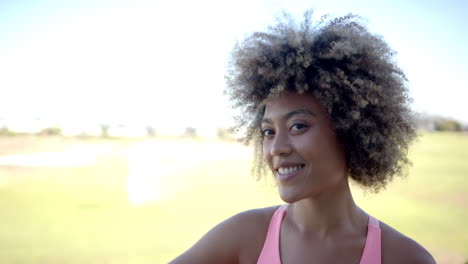 smiling woman with curly hair enjoying outdoor activity in casual attire
