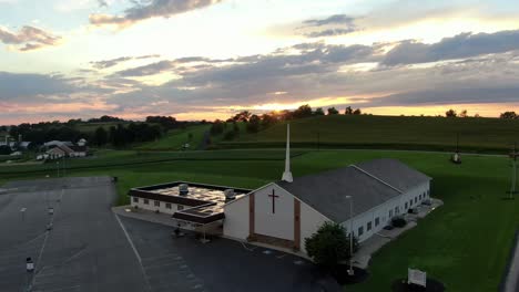 Aéreo,-Iglesia-Evangélica-Cristiana-Con-Campanario,-Fuera-Del-Edificio-Y-Hermoso-Amanecer-Espectacular,-Puesta-De-Sol-En-El-Cielo-Celestial,-Condado-De-Lancaster,-Pennsylvania