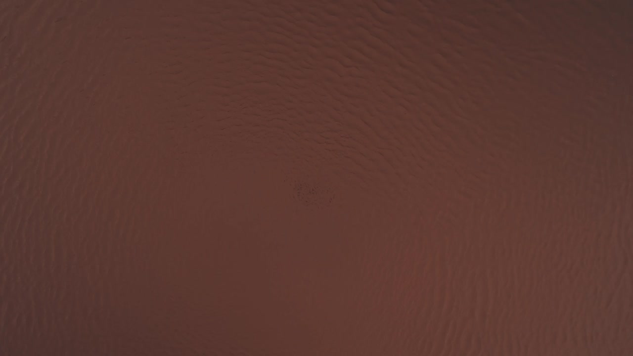 círculo de agua fangosa girando y extendiendo la superficie de movimiento en la sombra marrón claro.