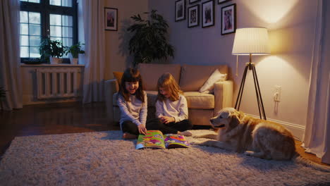 two sisters reading a book with a golden retriever in the living room