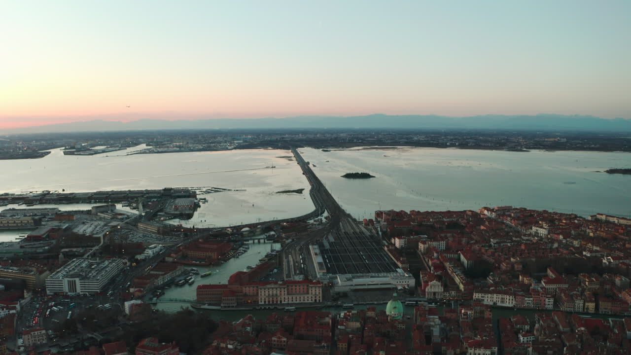 일몰 때 메스트레를 향해 베니스 산타루치아 기차역의 돌리 포워드 드론 샷