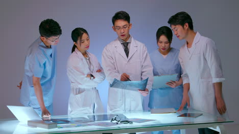 Young doctors and Team experts medical holding clipboard explaining diagnosis of patient in front of medicine experts during seminar. Clinic therapist discussing with colleagues about disease