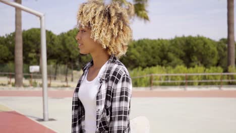 One-young-female-skater-walking-with-board-in-hand