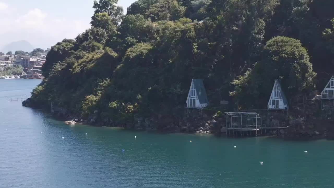 과테말라의 아티란 호수 (lago atitlán) 의 경이로운 풍경, 평온한 파란 물, 언덕에 있는 마을, 그리고 해안가에 있는 푸른 숲으로 인 절벽.