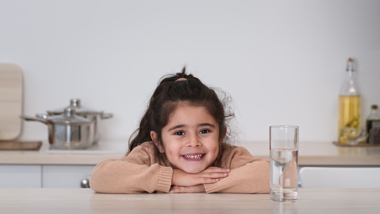Young Girl Drinking Water in the Kitchen