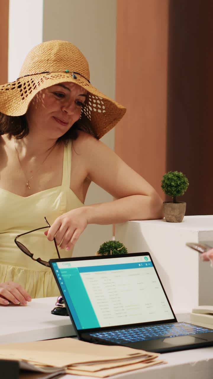 Vídeo vertical de concierge de hotel verificando documentos de identidade