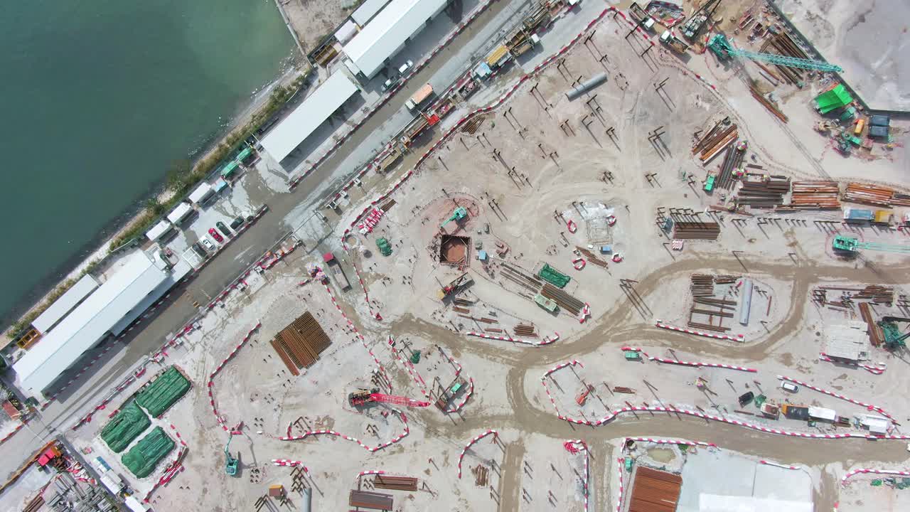 Converting an old runway strip into a Housing and business district at Kai Tak downtown Hong Kong, with vast infrastructure development land and an underwater tunnel laying operation, Aerial view.