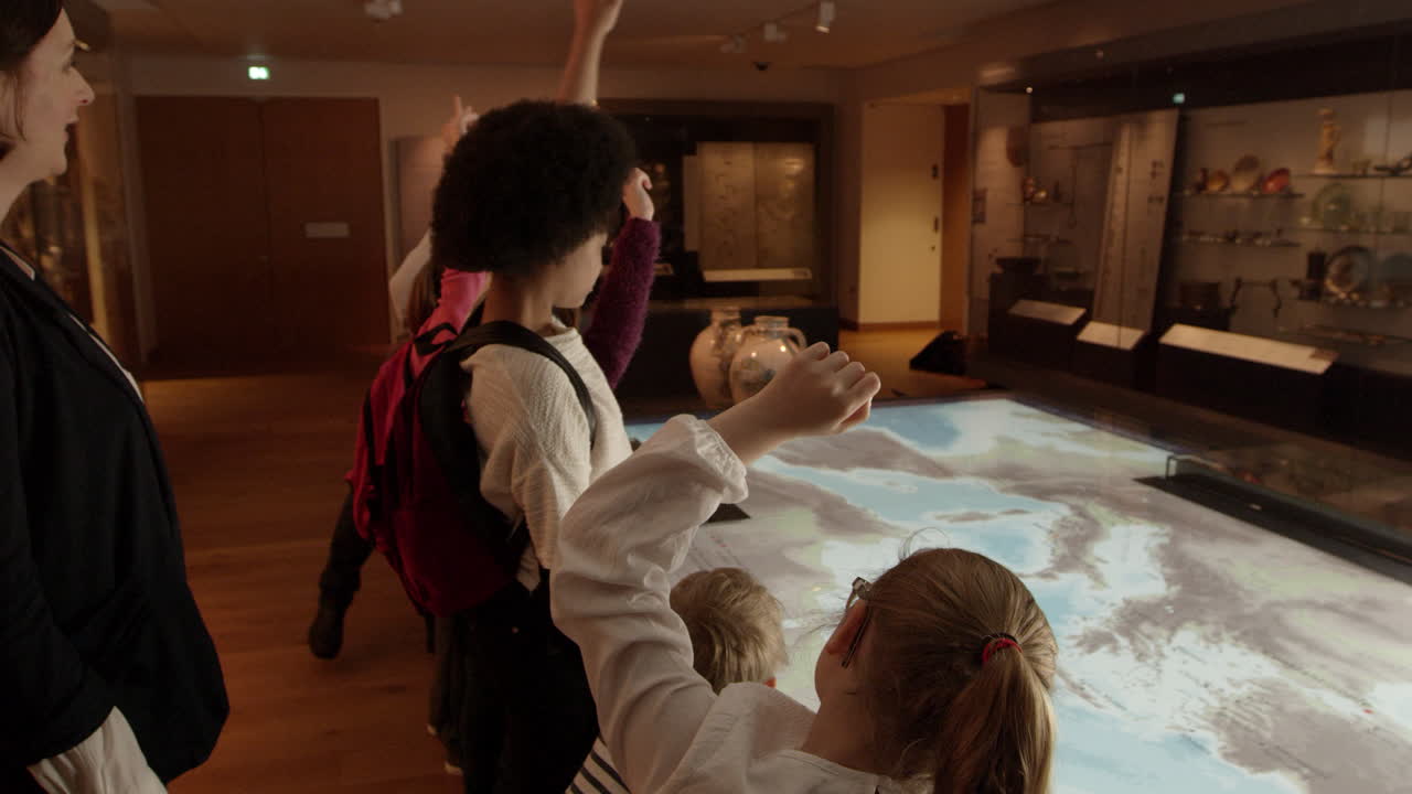 박물관 에 가는 학교 여행 에 있는 학생 들 이 r3d 에서 찍은 지도 를 보고 있다