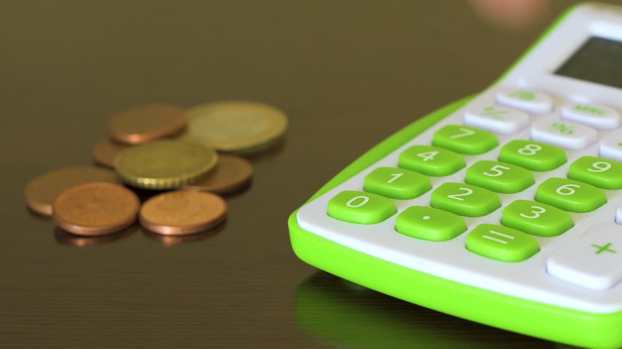 Una mano che digita su una calcolatrice. Economia familiare.