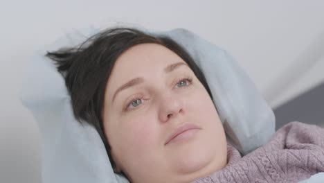 woman lying on the ct or mri scanner during machine imaging her body, lights up infrared rays and female patient passes through the circle, crane shot from down to up, room interior, active scene.