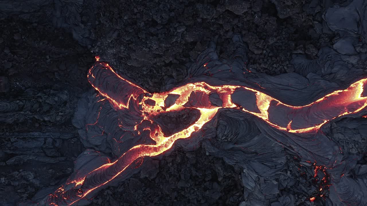 río de lava en movimiento lento en la fisura del volcán activo en islandia, de arriba hacia abajo
