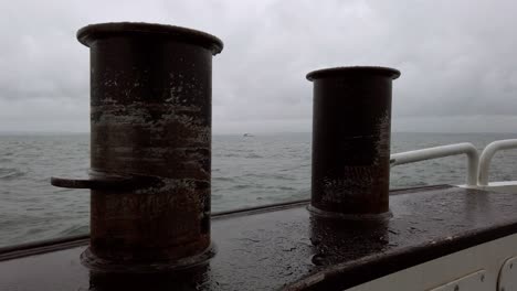 a small ship on the turbulent waters of lake constance, peering between two large cleats