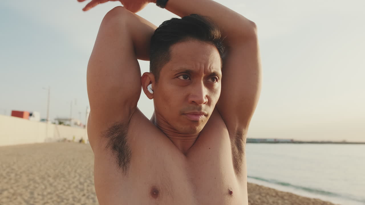 ビーチでストレッチをする男性