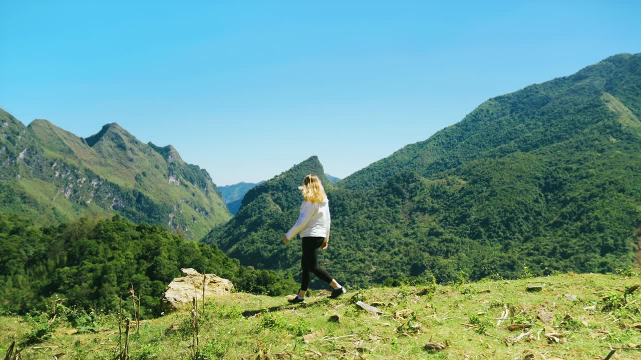 아름다운 산 계곡 꼭대기 에 팔 을 펴고 야외 풍경 을 즐기는 흥분 한 여자 의 뒷면