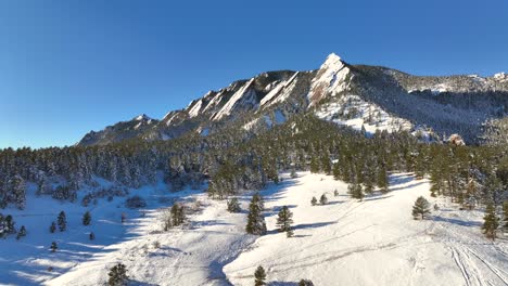 Sobrevuelo-Aéreo-Del-Paisaje-Natural-De-Chautauqua-Park-Flatirons-En-Boulder,-Colorado,-Estados-Unidos-En-Un-Brillante-Día-De-Invierno-Con-Suelo-Cubierto-De-Nieve