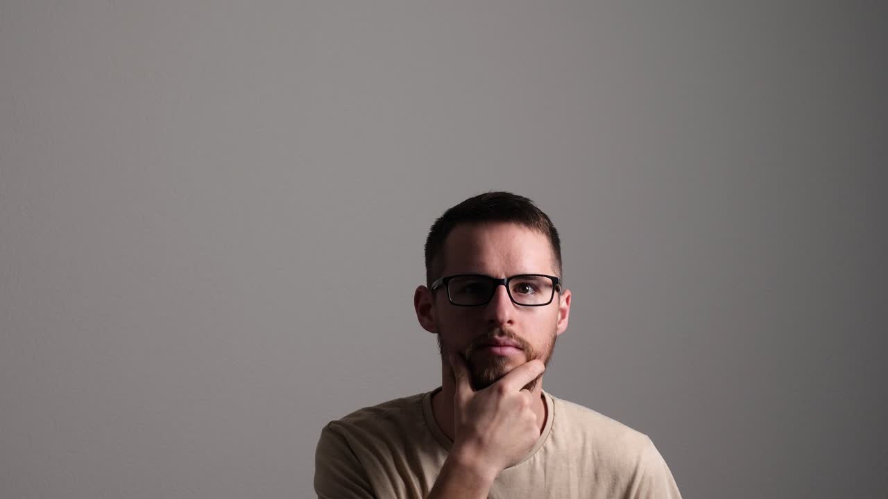 hombre creativo pensando, acariciando su barba y teniendo una idea