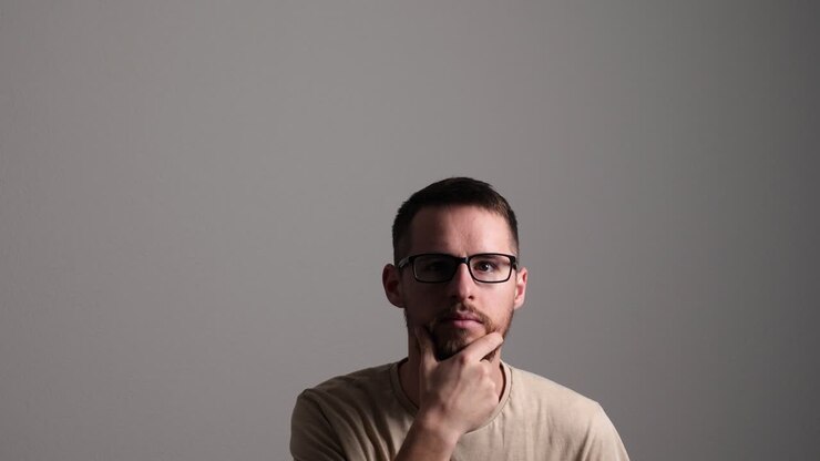 Uomo creativo che pensa, accarezzandosi la barba e avendo un'idea.