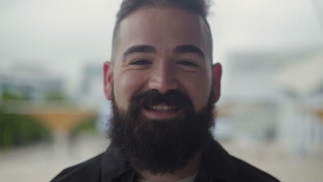 closeup shot of smiling bearded male face.