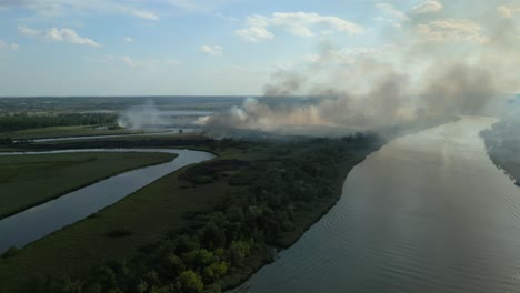 wildfire spreads along the odra river near szczecin, poland, smoke rising over the water