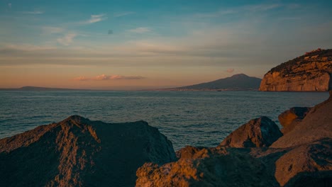 time-lapse-of-boat-driving-in-front-of-cliffs-in-Sorrento,-Italy-in-sunset-lighting