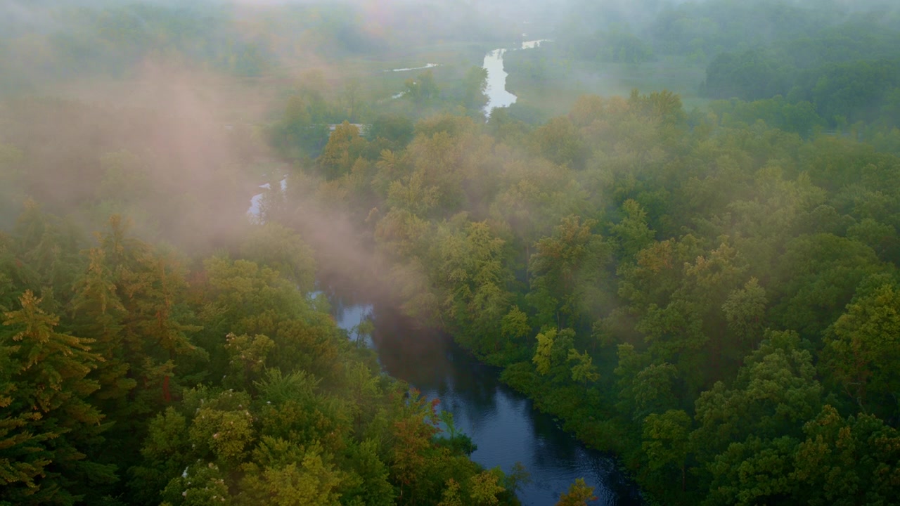 From above, the foggy Huron River at sunrise near Milford, Michigan, creates a tranquil scene.