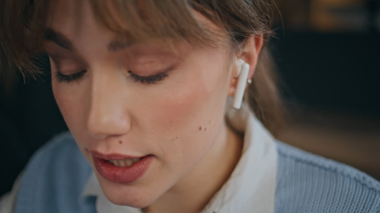 Emotional girl talking online conference by computer in dark interior closeup