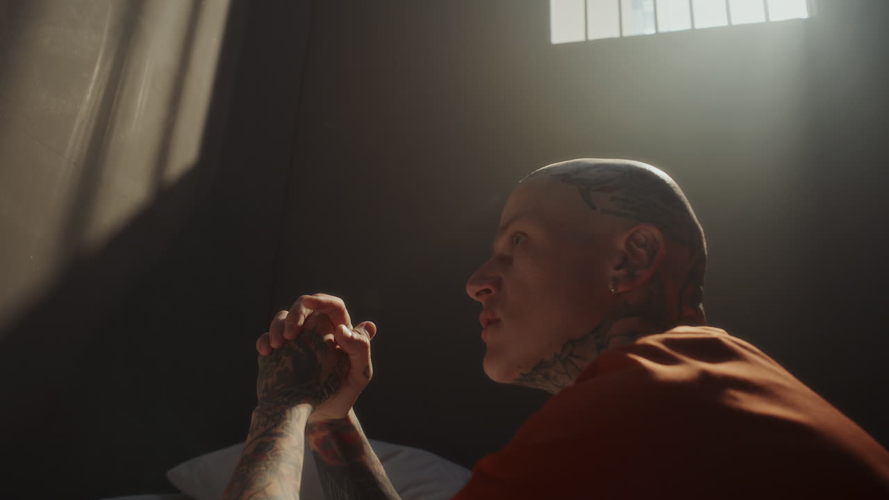 Tattooed Inmate Begging for Forgiveness during Prayer in Prison Cell