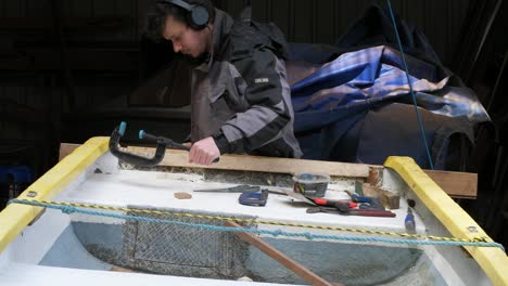 removing clamp from fibreglass boat transom in workshop