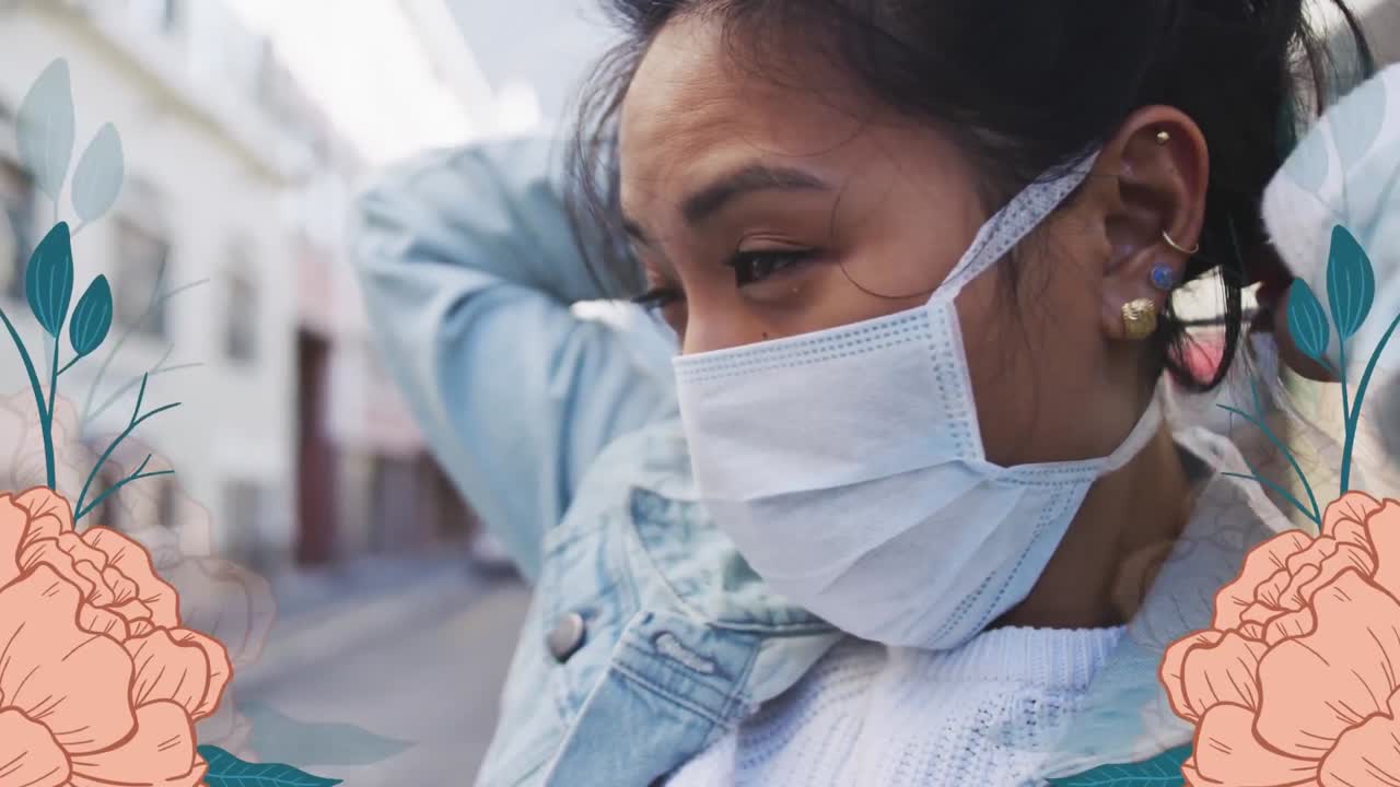 Animation of flowers over biracial women wearing face mask