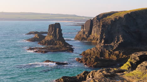 Aerial-dolly-along-rugged-rocky-coastline-with-sea-cliffs-of-scenic-Cornwall