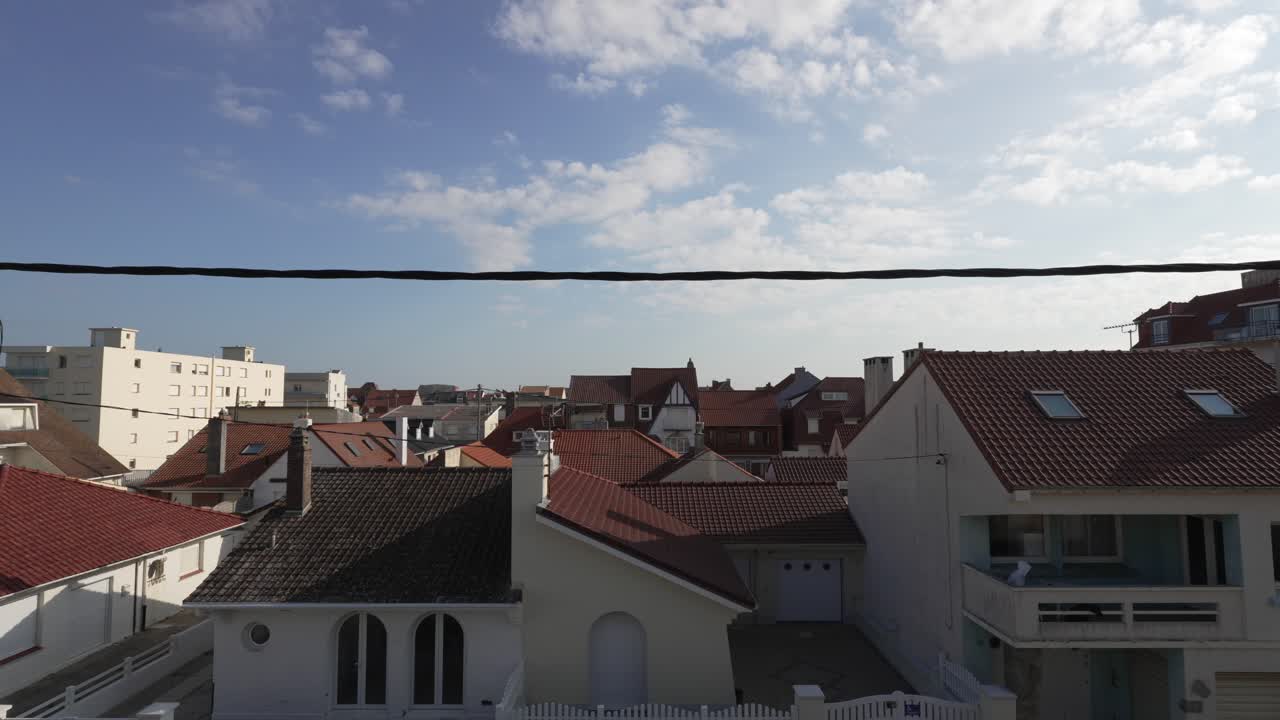 Rooftops fill the view over an Opal Coast town under blue sky