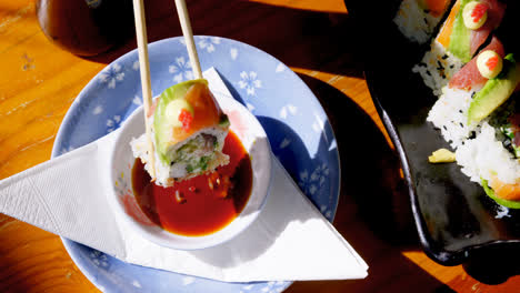 woman having sushi with sauce in restaurant 4k