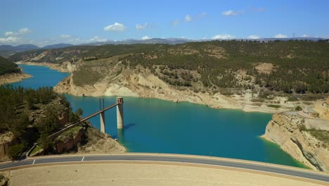 Drone-view-of-dam-with-road-closing-reservoir