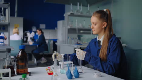 teenage girl performing an experiment in a school laboratory