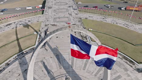 Bandera-Ondeando-Con-El-Viento-En-La-Plaza-De-La-Bandera-De-Santo-Domingo,-Tiro-A-Cámara-Lenta