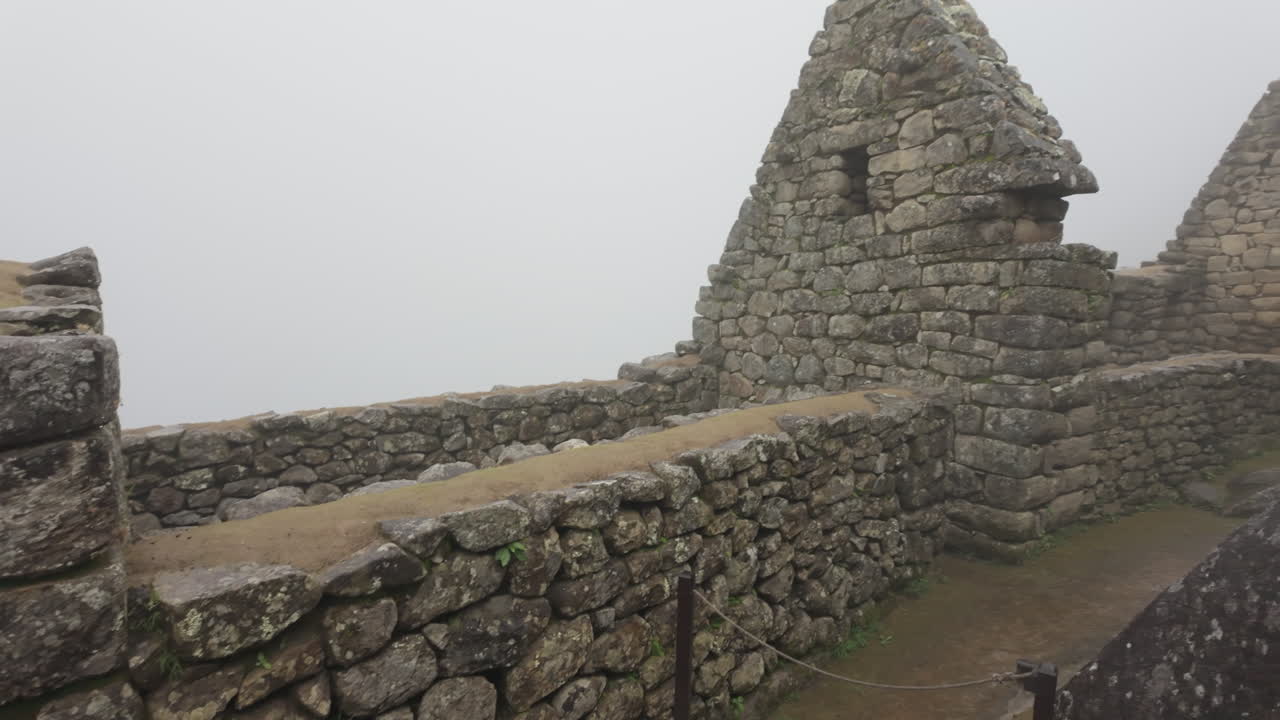 Slow motion video of Inca stone structures inside Machu Picchu, showing ancient walls and architecture in Peru