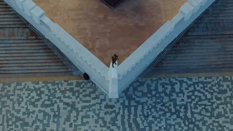 hombre de pie en el parapeto del monumento, extremo. pedestal de la ciudad, vista superior. vista aérea video desde el helicóptero. vista superior.