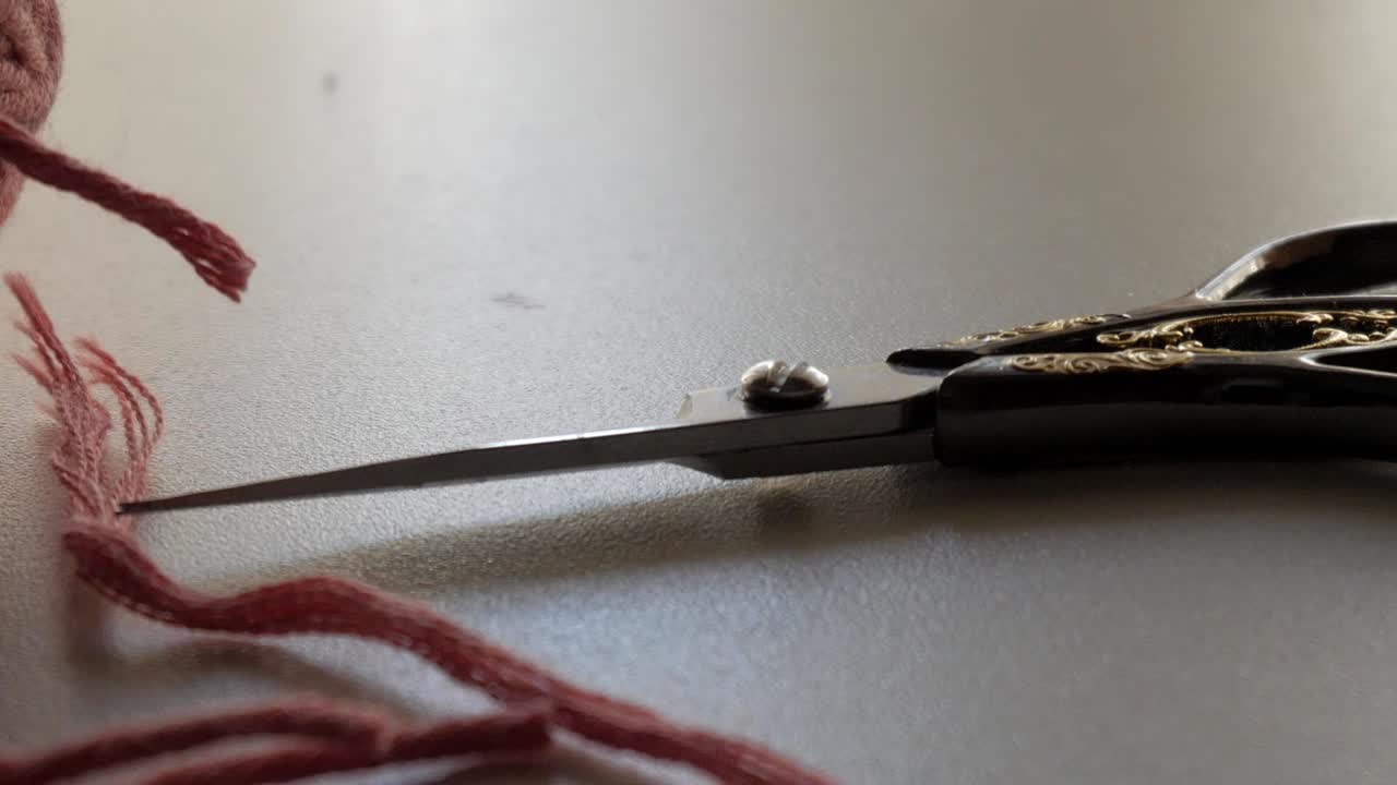 Close-up of Scissors and Red Yarn