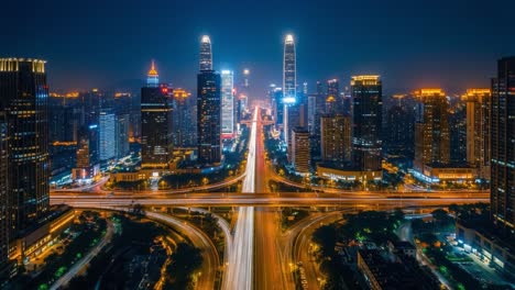 aerial night view of a modern city with light trails and skyscrapers