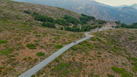 un disparo suave de un coche conduciendo a lo largo de una carretera montañosa con árboles y arbustos