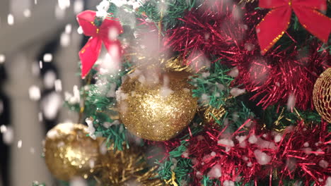 detail on golden christmas ball on the tree with snow falling