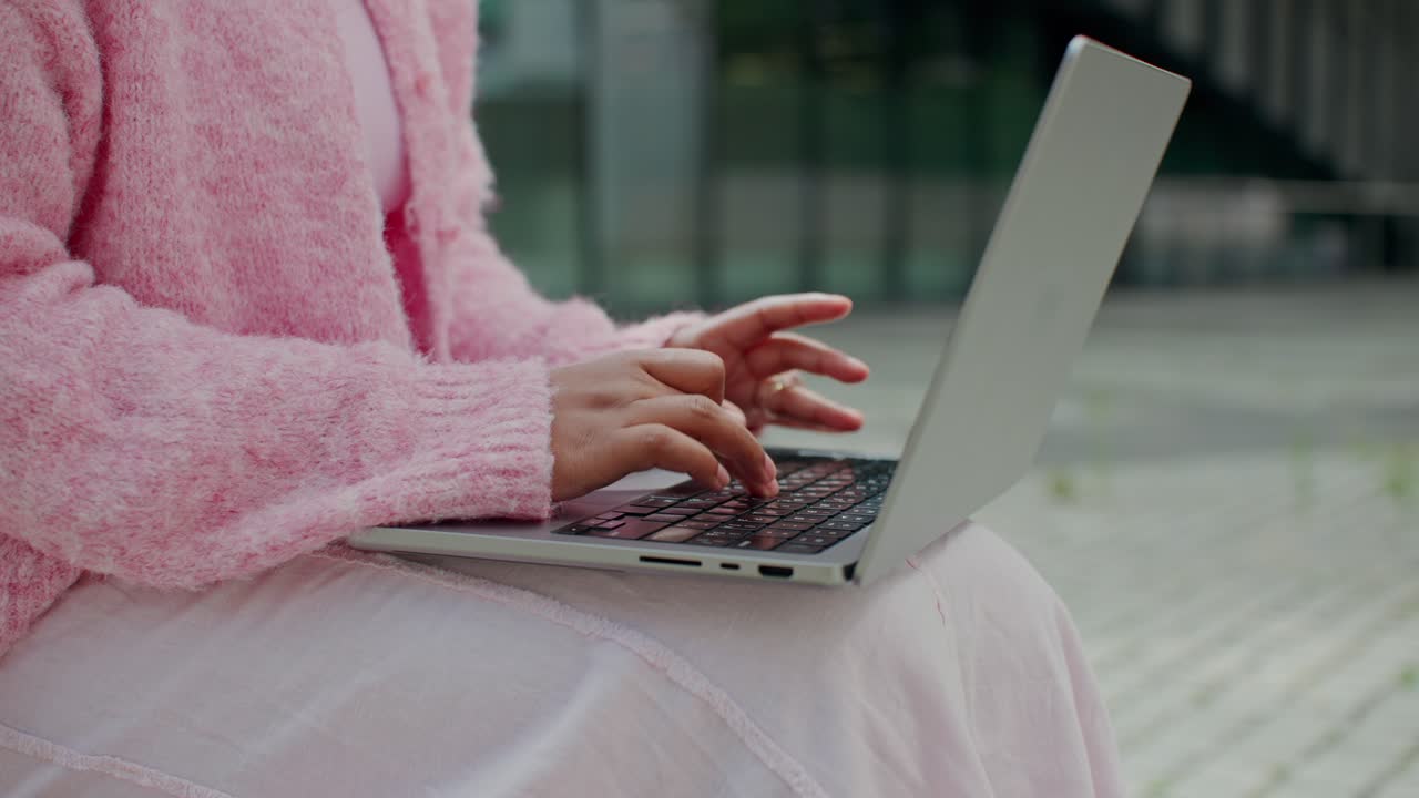 Donna che digita sul computer portatile all'aperto