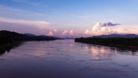 nubes de tormenta vespertinas burbujeando en la distancia con el río mekong fluyendo en primer plano