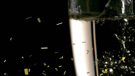 Animation-of-gold-confetti-falling-over-glass-of-champagne