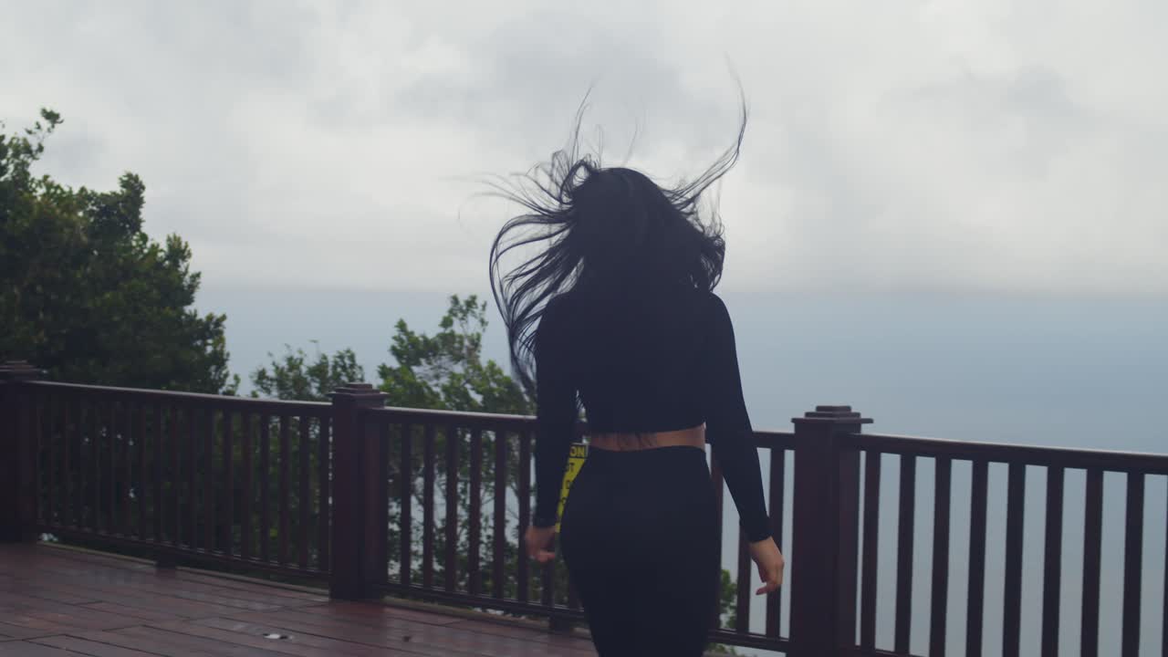 The scenic beauty of Trinidad’s coast is fully enjoyed by a young Latina at the famous lookout point