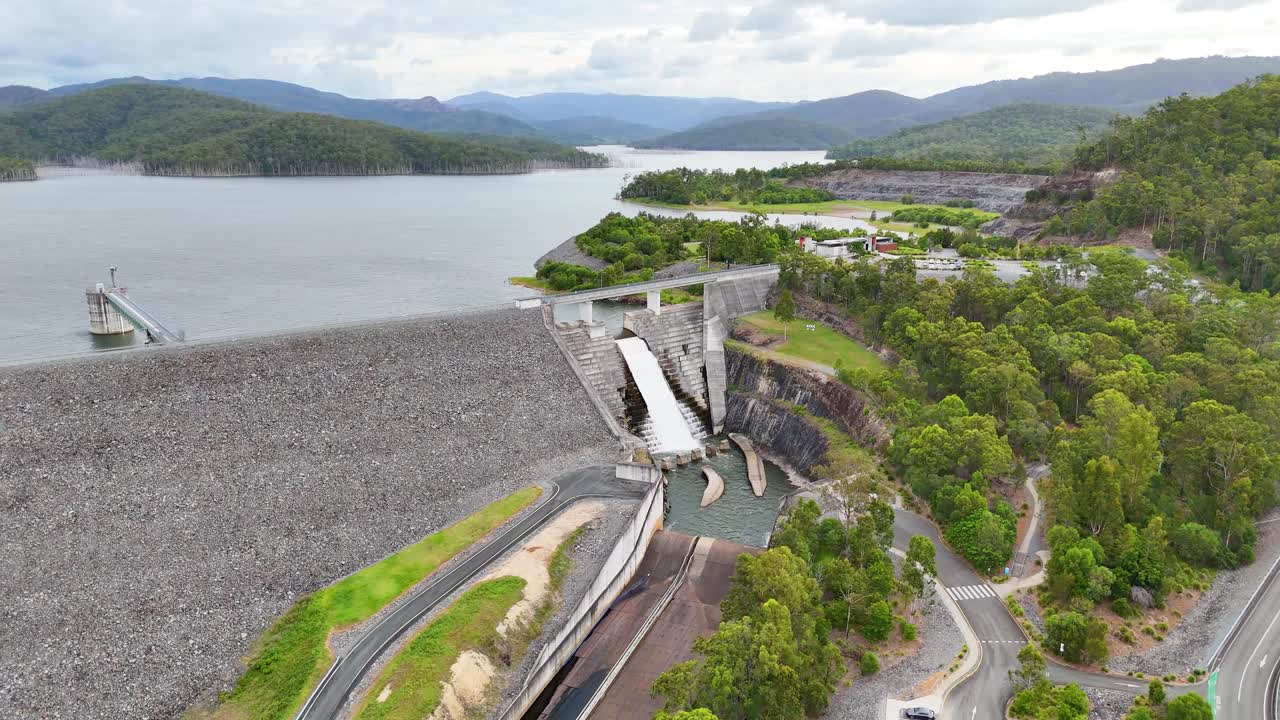 Drone footage of water flowing over dam