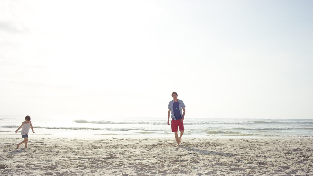 해가 지는 해변에서 딸을 흔들고 재미있게 놀고 있습니다.
