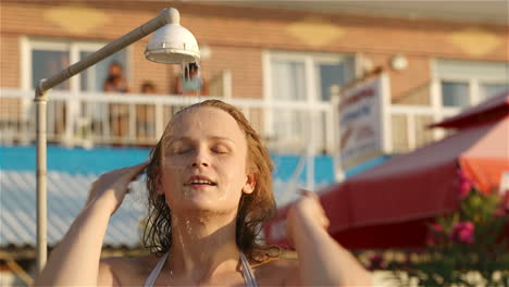 woman rinsing of at the beach under a shower